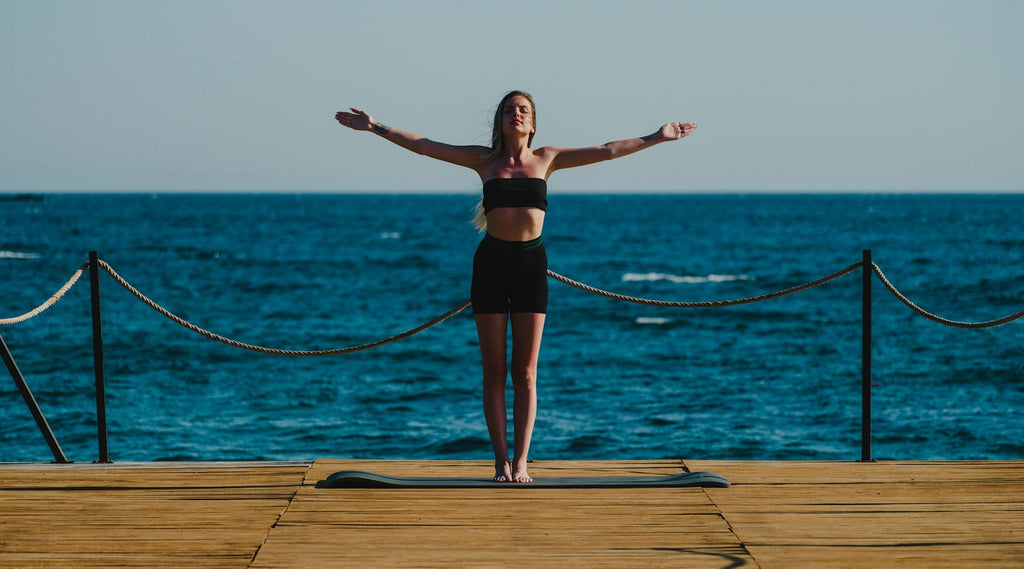 Lady by the sea in a balanced, mindful zen pose